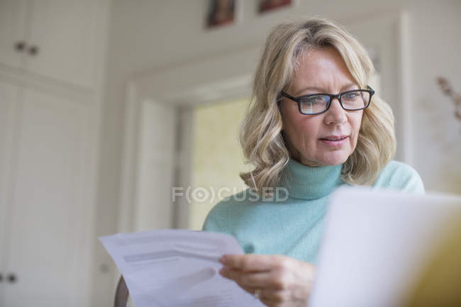 Mature female freelancer working at laptop at home — Stock Photo
