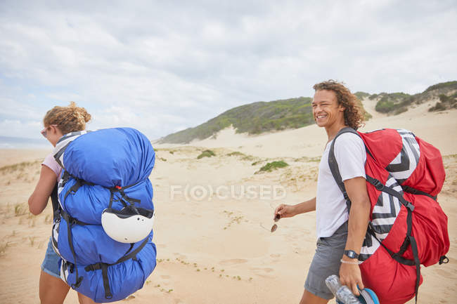 Portrait happy male paraglider with parachute backpack on beach — Stock Photo