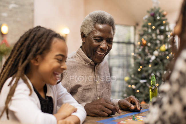 Sorrindo avô e neta jogando jogo de tabuleiro — Fotografia de Stock