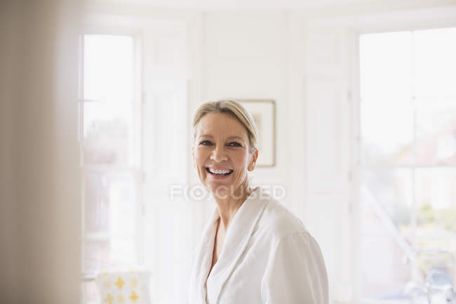 Portrait smiling, confident mature woman in bathrobe — Stock Photo