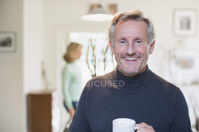 Retrato sonriente, confiado hombre maduro bebiendo té - foto de stock
