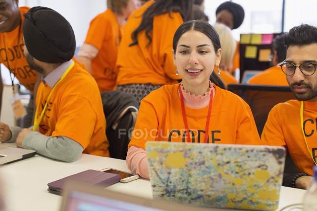 Hackers at laptop coding for charity at hackathon — Stock Photo