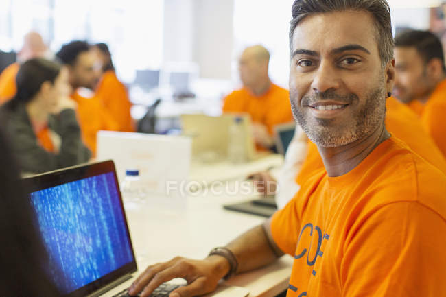 Retrato hacker confiante no laptop codificação para caridade no hackathon — Fotografia de Stock