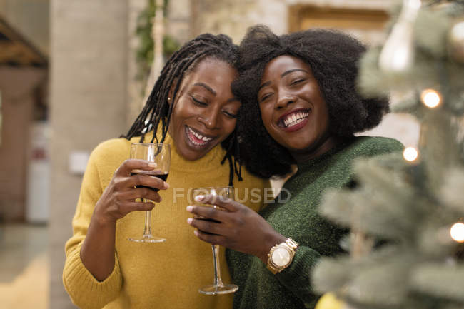 Retrato sonriente, madre feliz e hija abrazándose, bebiendo vino - foto de stock