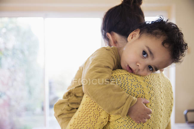 Felice madre caucasica che abbraccia a casa il figlio afroamericano — Foto stock
