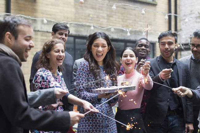 Friends celebrating with woman holding birthday cake — Stock Photo