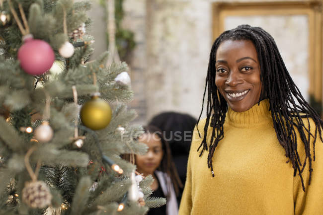 Retrato sonriente, mujer confiada en el árbol de Navidad - foto de stock