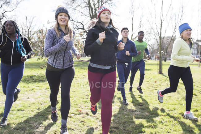 Gruppo di corridori che corrono nel parco soleggiato — Foto stock