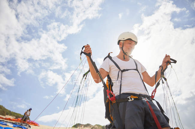 Mature male paraglider preparing equipment — Stock Photo