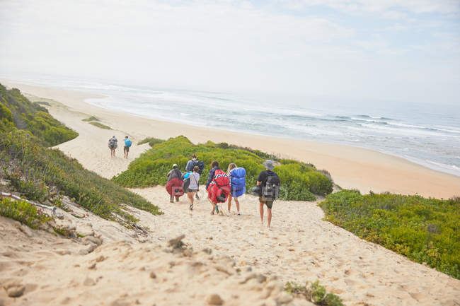 Параглідери, що перевозять парашутні рюкзаки на океанічному пляжі — стокове фото