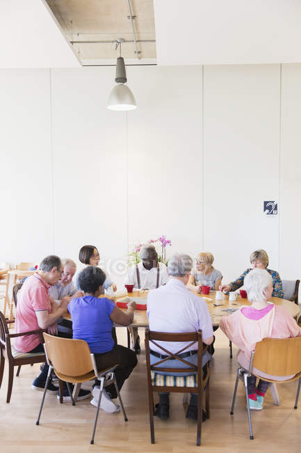 Seniorenfreunde spielen am Tisch im Bürgerhaus — Stockfoto