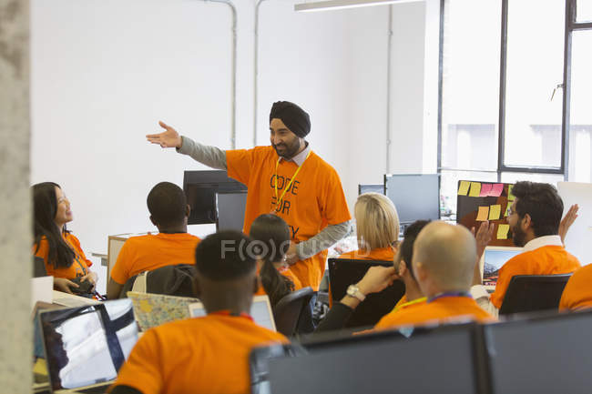 Hacker in turban leading meeting, coding for charity at hackathon — Stock Photo