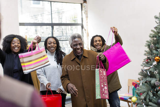 Famille multi-génération enthousiaste arrivant avec des cadeaux de Noël — Photo de stock