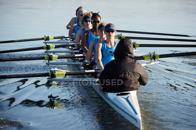 Female rowers rowing scull on lake — Stock Photo