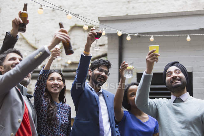 Друзья пьют напитки на вечеринке во внутреннем дворике — стоковое фото