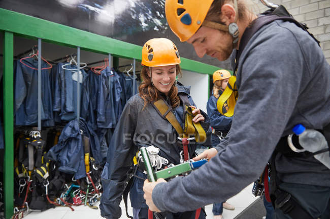 Man helping woman with zip line equipment — Stock Photo