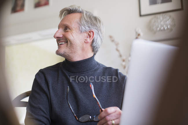 Sonriente maduro freelancer masculino trabajando en el portátil - foto de stock