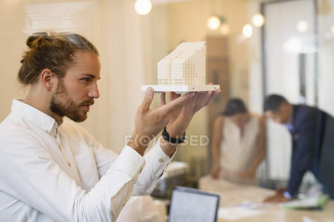 Ориентированный, любопытный мужчина-архитектор рассматривает модель — стоковое фото