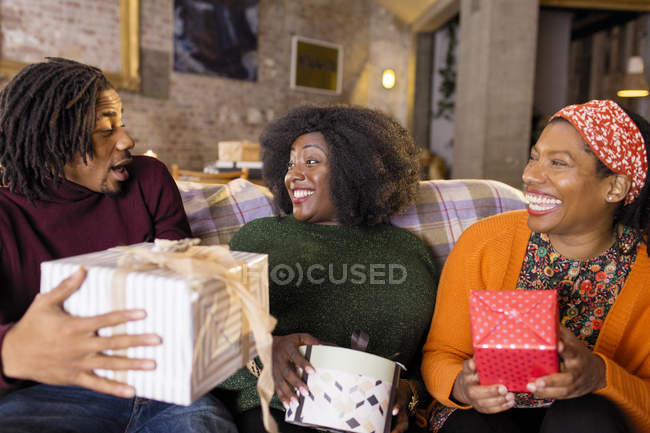 Enthusiastic family opening Christmas gifts — Stock Photo