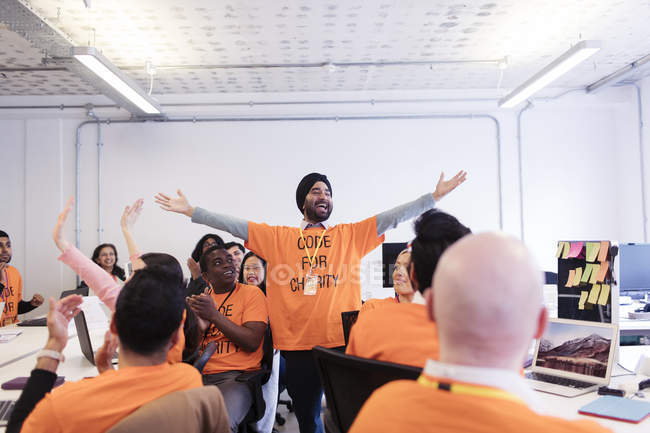 Exuberant hackers cheering, coding for charity at hackathon — Stock Photo