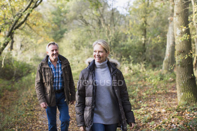 Зрелая кавказская пара, гуляющая вместе в осеннем парке — стоковое фото