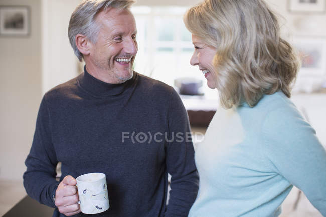 Smiling mature couple talking and drinking coffee — Stock Photo