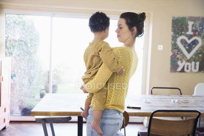Feliz mãe caucasiana com filho afro-americano em casa — Fotografia de Stock