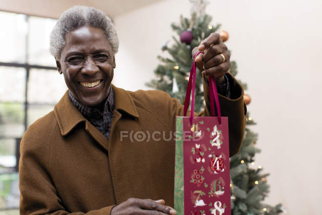 Ritratto uomo anziano sorridente con regalo di Natale — Foto stock