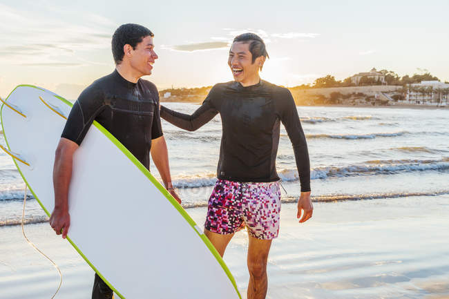 Glückliche männliche Surfer am Strand des Ozeans — Stockfoto