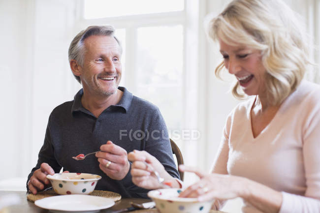Sorridente coppia matura che fa colazione a casa moderna — Foto stock