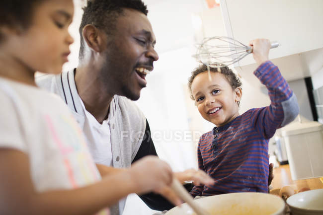 Отец и дети пекут на кухне — стоковое фото