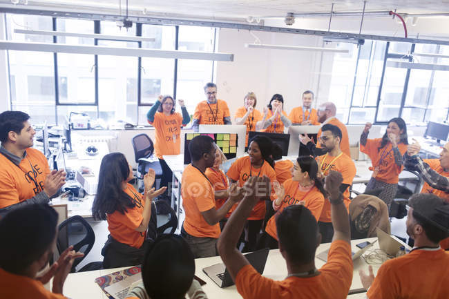 Hackers celebrating, coding for charity at hackathon — Stock Photo