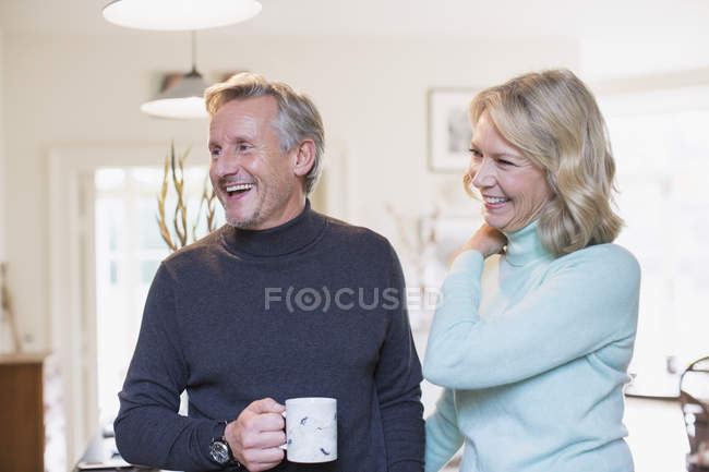 Riendo pareja madura bebiendo té - foto de stock