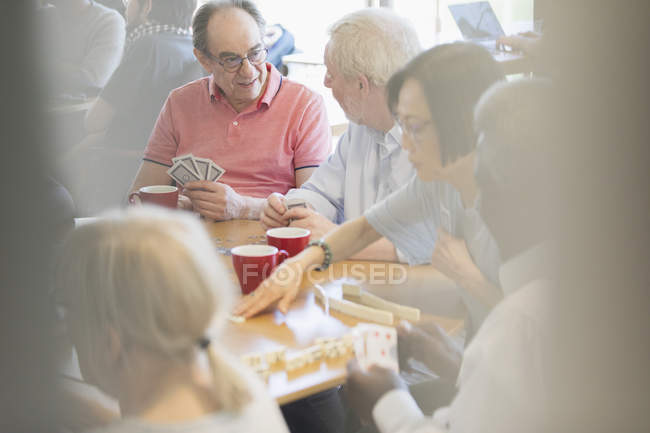 Старші друзі грають в ігри за столом у громадському центрі — стокове фото