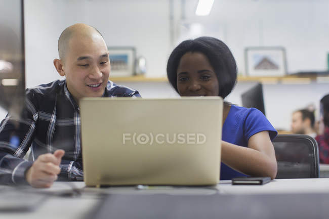 Empresário e empresária usando laptop no escritório — Fotografia de Stock