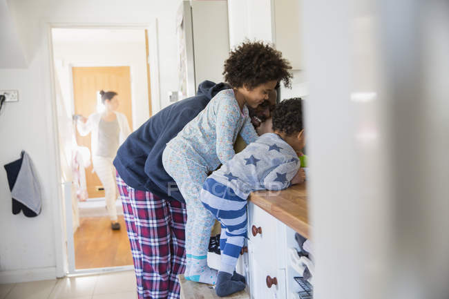 Батько і діти в піжамі на кухонній стійці — стокове фото