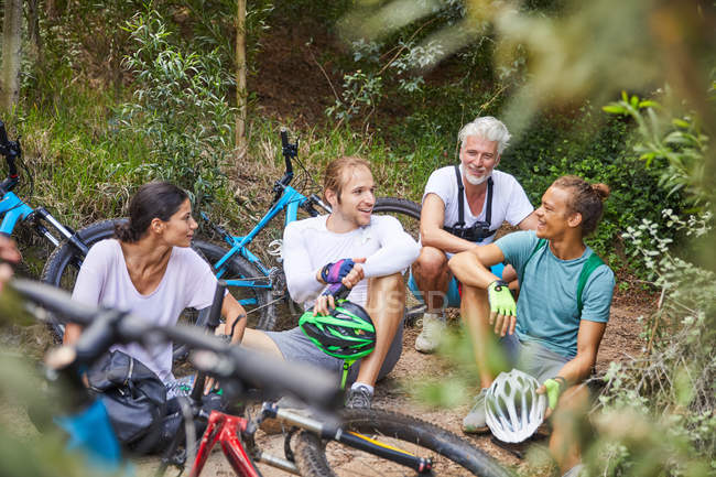 Amigos ciclismo de montaña, descansando en el bosque - foto de stock