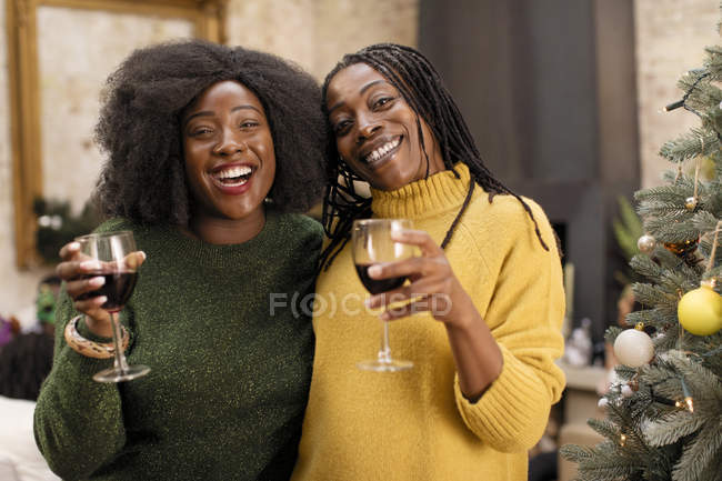 Портрет усміхнений, щаслива мати і дочка п'ють вино поруч з ялинкою — стокове фото