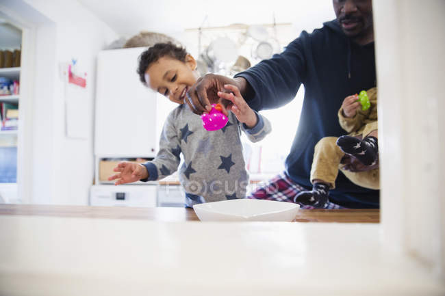 Afroamericano padre jugando con niños en casa - foto de stock