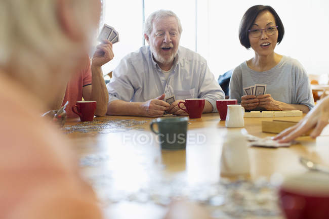 Amigos sênior jogando jogos à mesa no centro da comunidade — Fotografia de Stock