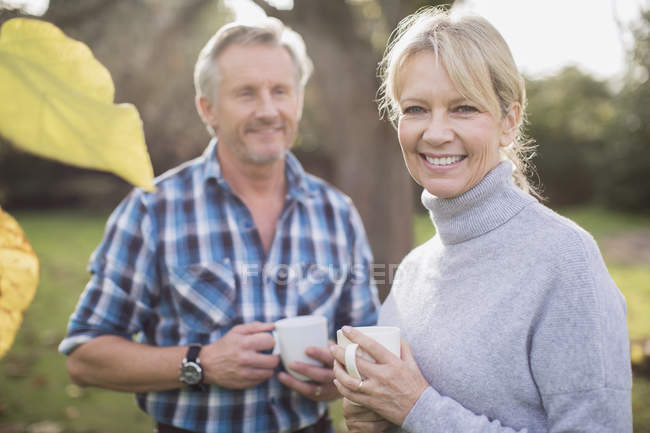 Mature caucasian couple drinking coffee in garden — Stock Photo