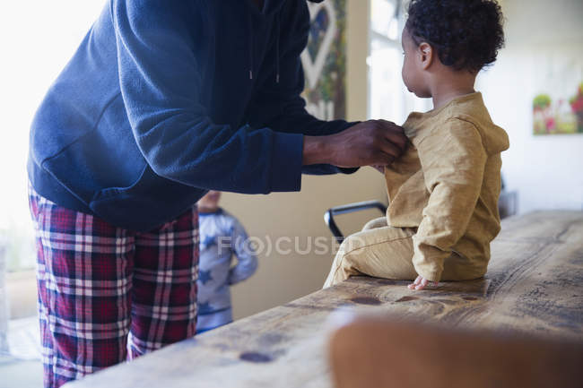 Vista lateral del padre afroamericano con su pequeño hijo en casa - foto de stock