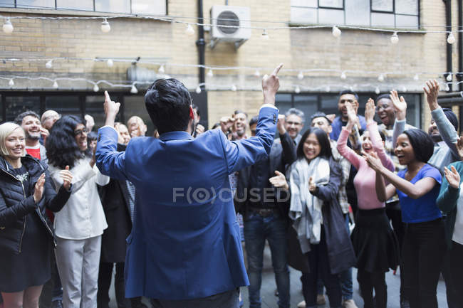 Business people cheering for businessman, celebrating on patio — Stock Photo