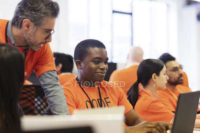 Hackers at laptops coding for charity at hackathon — Stock Photo