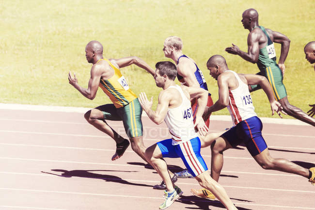 Sprinters corrida na pista — Fotografia de Stock