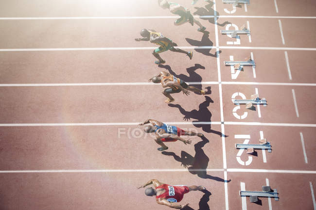 Runners taking off from starting blocks on track — Stock Photo
