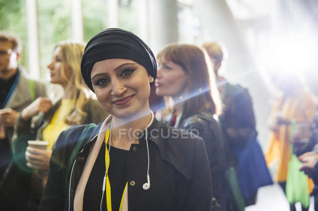 Retrato sonriente mujer en pañuelo en la cabeza en la conferencia - foto de stock