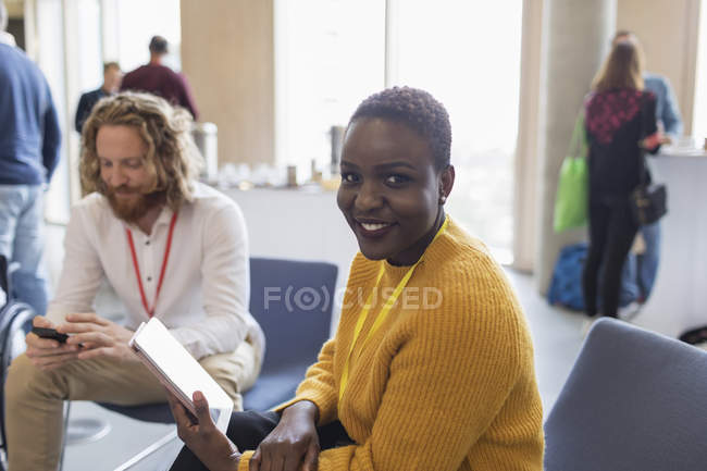 Portrait smiling businesswoman with digital tablet at conference — Stock Photo