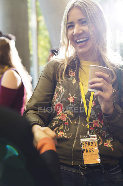 Lächelnde Frau mit Kaffee bei Konferenz im modernen Büro — Stockfoto