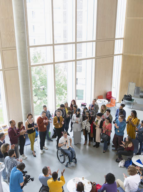 Le public de la conférence applaudit pour une conférencière en fauteuil roulant — Photo de stock